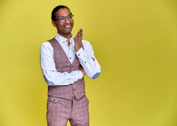 Portrait of a young African American man with short haircuts and a white-toothed smile in a business suit on a yellow background. Standing and talking right in front of the camera. — Stock Photo, Image