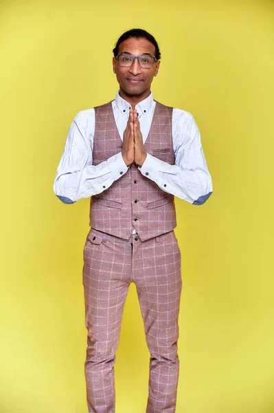 Vertikales Porträt eines jungen Mannes mit kurzhaarigen Afroamerikanern im Businessanzug auf gelbem Hintergrund. direkt vor der Kamera stehen und reden. — Stockfoto