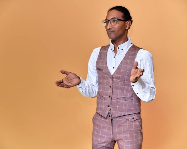 Kısa saçlı, beyaz dişli, pembe arka planda iş elbisesi giymiş genç bir Afro-Amerikan 'ın portresi. Kameranın önünde dikilip konuşmak..