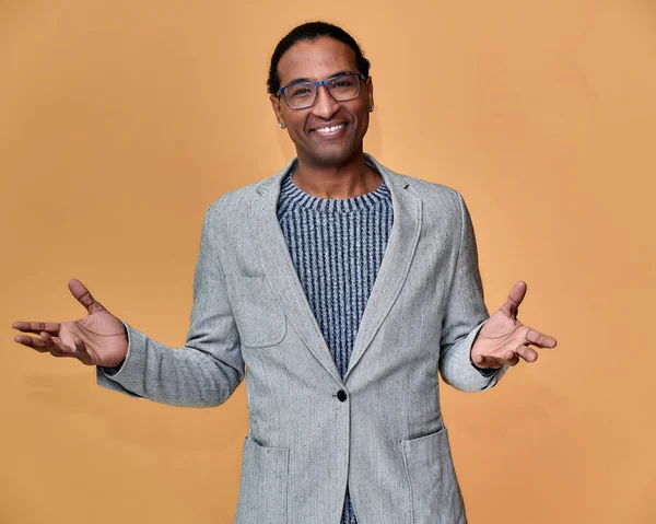 Porträtt av en ung afroamerikansk man med kort hår och ett vitt tandat leende i en grå jacka på en rosa bakgrund. Stå och prata framför kameran. — Stockfoto