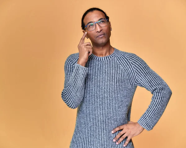 Porträtt av en ung afroamerikansk man i glasögon med en kort frisyr och med ett vitt-tandat leende i en grå tröja på en rosa bakgrund. Stå och prata framför kameran. — Stockfoto