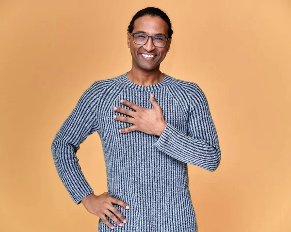 Portré egy fiatal afro-amerikai férfiról szemüvegben, rövid hajjal, fehér fogú mosollyal, szürke pulóverben, rózsaszín háttérrel. Állni és beszélni a kamera előtt.. — Stock Fotó