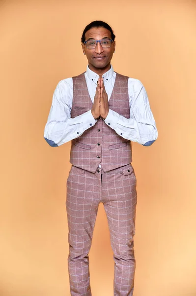 Retrato vertical Joven con afroamericano de pelo corto en un traje de negocios sobre un fondo rosa. De pie y hablando delante de la cámara . —  Fotos de Stock