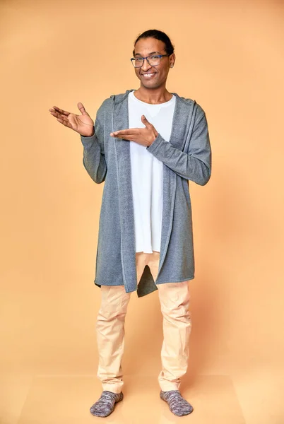 Das vertikale Porträt eines fröhlichen jungen Mannes mit Brille afrikanisch-amerikanisch mit Kurzhaarschnitt in gewöhnlicher Kleidung auf rosa Hintergrund in voller Länge. direkt vor der Kamera stehen — Stockfoto