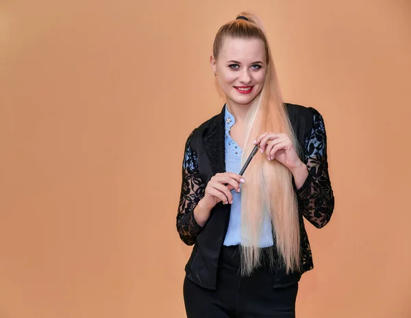 Concepto de negocio chica rubia se para delante de la cámara. Retrato de una mujer gerente en un traje de negocios con pelo largo y hermoso y excelente maquillaje sobre un fondo rosa . — Foto de Stock