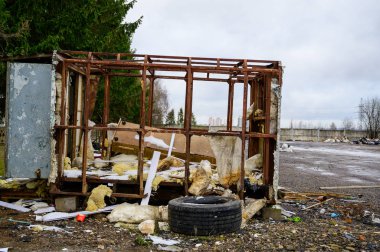 Çöp konsepti çevre felaketi. Bulutlu bir günde şehrin bir caddesindeki çöplükte harap olmuş bir kulübenin fotoğrafı..