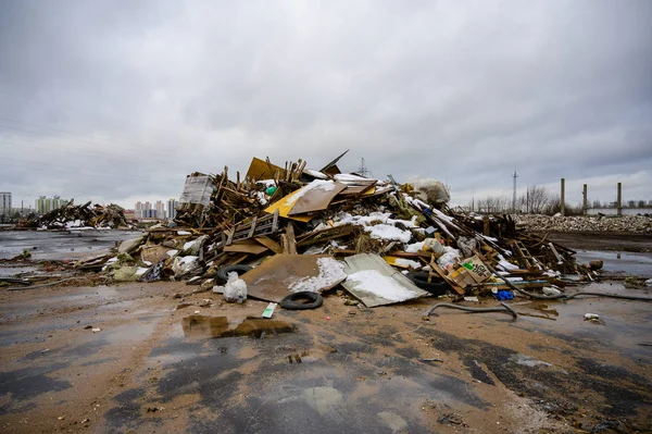 The concept of trash environmental disaster. Photo of a landfill on a street in a city on a cloudy day.