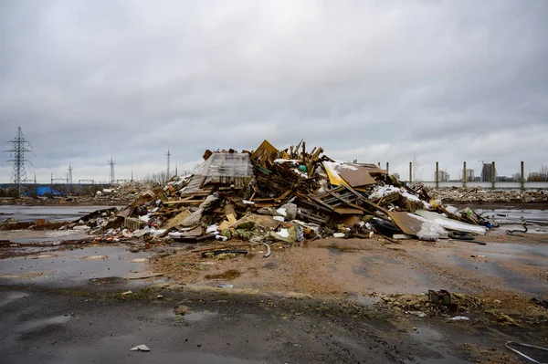 The concept of trash environmental disaster. Photo of a landfill on a street in a city on a cloudy day.