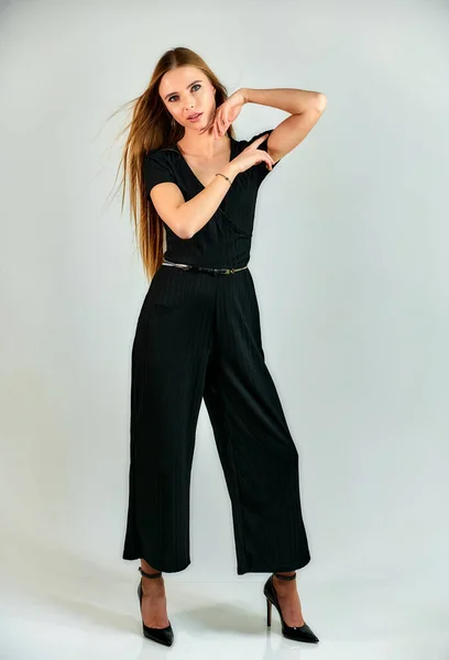 Ritratto a figura intera di una bella ragazza bionda con i capelli lunghi e un trucco eccellente su uno sfondo bianco. Modello studente manager stand in diverse pose di fronte alla telecamera in studio . — Foto Stock