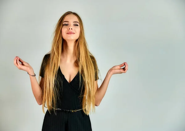 El concepto de moda y estilo. Retrato de una bonita chica rubia con el pelo largo y un gran maquillaje sobre un fondo blanco. El modelo se coloca en diferentes posturas delante de la cámara . —  Fotos de Stock