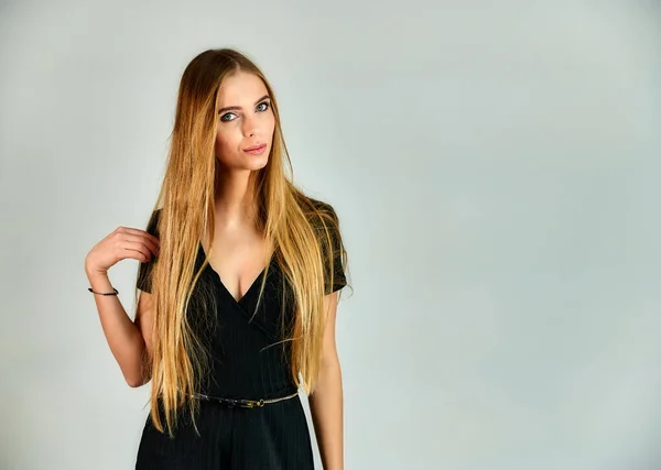 Das Konzept von Mode und Stil. Porträt eines hübschen blonden Mädchens mit langen Haaren und tollem Make-up auf weißem Hintergrund. das Model steht in verschiedenen Posen vor der Kamera. — Stockfoto