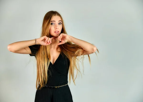 The model stands in different poses in front of the camera. The concept of fashion and style. Portrait of a pretty blonde girl with long hair and great makeup on a white background. — Stok fotoğraf