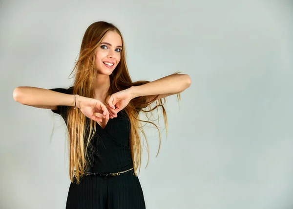 The model stands in different poses in front of the camera. The concept of fashion and style. Portrait of a pretty blonde girl with long hair and great makeup on a white background. — Stockfoto