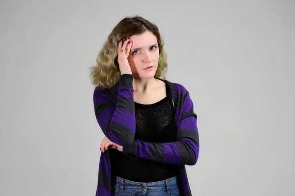 Porträtt av en söt elev med vackert lockigt hår. Begreppet horisontellt foto av en ung kvinna med känslor i en mörk jacka står framför kameran på en vit bakgrund. — Stockfoto