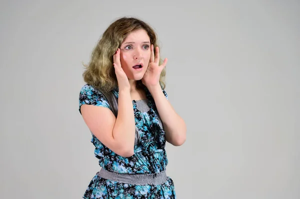 Concept horizontal photo of a young woman with emotions in a turquoise dress stands in front of the camera on a white background. Portrait of a student girl with beautiful magnificent hair. — 스톡 사진