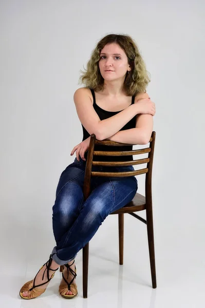 Una joven sentada en una silla — Foto de Stock