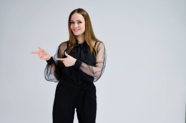 Çok güzel gülümseyen esmer bir kızın fotoğrafı koyu renk elbiseli mükemmel makyajlı beyaz bir arka planda duygularla duruyor. Bir afiş için konsept portresi.