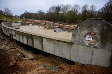 Sokakta beton duvar inşaatı. Şehirdeki parkın işleri ve gelişimi. Çimento ve kumdan bir temel yaratmak.