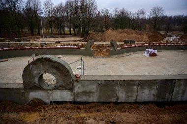 Sokakta beton duvar inşaatı. Şehirdeki parkın işleri ve gelişimi. Çimento ve kumdan bir temel yaratmak.