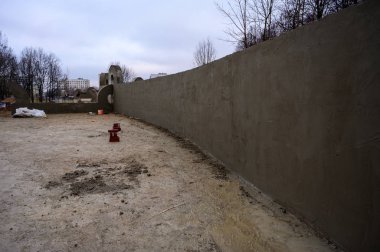 Sokakta beton duvar inşaatı. Şehirdeki parkın işleri ve gelişimi. Çimento ve kumdan bir temel yaratmak.