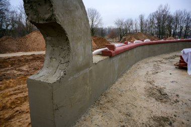 Sokakta beton duvar inşaatı. Şehirdeki parkın işleri ve gelişimi. Çimento ve kumdan bir temel yaratmak.
