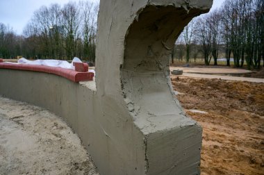 Sokakta beton duvar inşaatı. Şehirdeki parkın işleri ve gelişimi. Çimento ve kumdan bir temel yaratmak.
