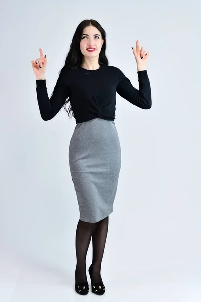 Portrait of a pretty brunette girl with a smile with long hair with excellent makeup in a gray dress on a white background is standing straight. Concept of business female photo portrait. — Stock Photo, Image