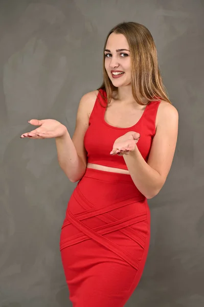 長い髪と異なるポーズで感情を持つ赤いドレスで素晴らしいメイクを持つかなり笑顔の女の子の垂直写真。女性像の普遍的な概念. — ストック写真