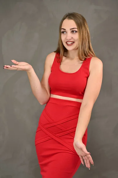 Foto vertical de una chica muy sonriente con el pelo largo y un gran maquillaje en un vestido rojo con emociones en diferentes poses. Concepto universal de retrato femenino . —  Fotos de Stock