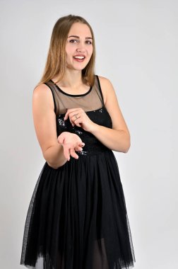 Uzun saçlı, harika makyajlı ve gülümseyen güzel bir kızın fotoğrafı stüdyoda çeşitli pozlarda duruyor. Beyaz arka planda evrensel konsept dikey kadın portresi.