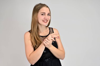 Beyaz arka planda bir kadının evrensel konsept yatay portresi. Siyah elbiseli, uzun saçlı ve mükemmel makyajlı güzel bir kızın fotoğrafı farklı pozlarda duruyor..