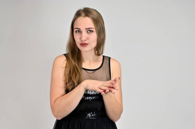 Beyaz arka planda bir kadının evrensel konsept yatay portresi. Siyah elbiseli, uzun saçlı ve mükemmel makyajlı güzel bir kızın fotoğrafı farklı pozlarda duruyor..