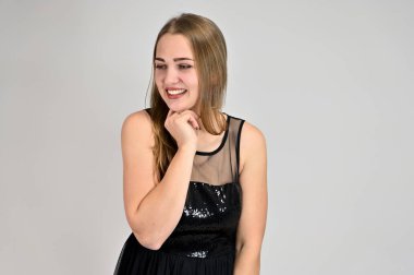 Beyaz arka planda bir kadının evrensel konsept yatay portresi. Siyah elbiseli, uzun saçlı ve mükemmel makyajlı güzel bir kızın fotoğrafı farklı pozlarda duruyor..