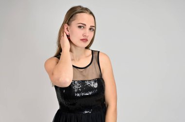 Beyaz arka planda bir kadının evrensel konsept yatay portresi. Siyah elbiseli, uzun saçlı ve mükemmel makyajlı güzel bir kızın fotoğrafı farklı pozlarda duruyor..