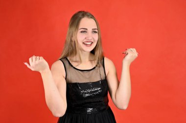 Kırmızı arka planda evrensel konsept yatay kadın portresi. Siyah elbiseli, uzun saçlı ve mükemmel makyajlı güzel bir kızın fotoğrafı farklı pozlarda duruyor..