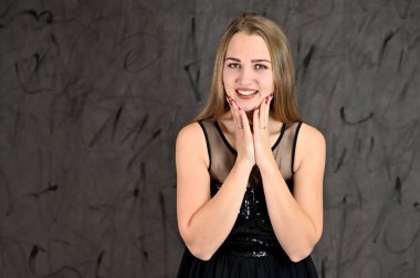 Gri arka planda evrensel yatay kadın portresi konsepti. Siyah elbiseli, uzun saçlı ve mükemmel makyajlı güzel bir kızın fotoğrafı farklı pozlarda duruyor..