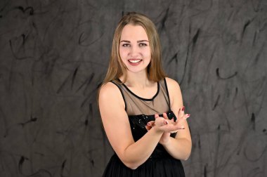 Gri arka planda evrensel yatay kadın portresi konsepti. Siyah elbiseli, uzun saçlı ve mükemmel makyajlı güzel bir kızın fotoğrafı farklı pozlarda duruyor..