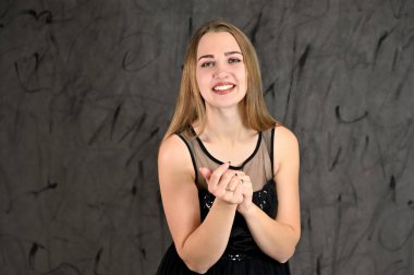 Gri arka planda evrensel yatay kadın portresi konsepti. Siyah elbiseli, uzun saçlı ve mükemmel makyajlı güzel bir kızın fotoğrafı farklı pozlarda duruyor..