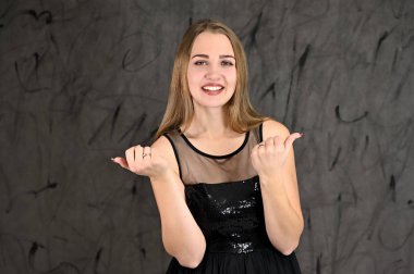 Gri arka planda evrensel yatay kadın portresi konsepti. Siyah elbiseli, uzun saçlı ve mükemmel makyajlı güzel bir kızın fotoğrafı farklı pozlarda duruyor..