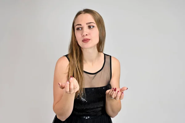 Universal concept horizontal portrait of a woman on a white background. A photo of a pretty smiling girl with long hair and excellent make-up in a black dress stands in different poses. — Stock Photo, Image