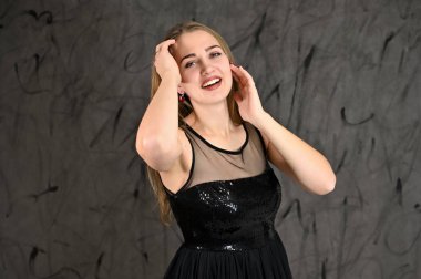 Gri arka planda evrensel yatay kadın portresi konsepti. Siyah elbiseli, uzun saçlı ve mükemmel makyajlı güzel bir kızın fotoğrafı farklı pozlarda duruyor..