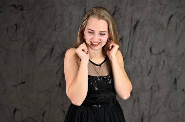 Gri arka planda evrensel yatay kadın portresi konsepti. Siyah elbiseli, uzun saçlı ve mükemmel makyajlı güzel bir kızın fotoğrafı farklı pozlarda duruyor..