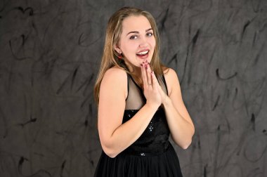 Gri arka planda evrensel yatay kadın portresi konsepti. Siyah elbiseli, uzun saçlı ve mükemmel makyajlı güzel bir kızın fotoğrafı farklı pozlarda duruyor..