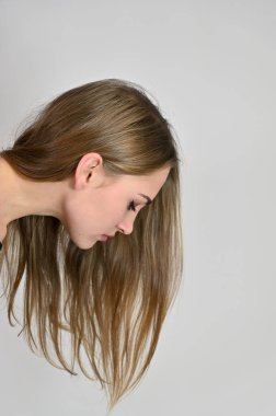 Beyaz arka planda kozmetik reklamcılığı için genel kadın portresi konsepti. Uzun saçlı ve mükemmel makyajlı güzel bir kızın büyük bir fotoğrafı farklı pozlarda duruyor..