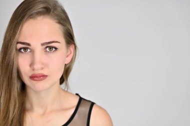 Beyaz arka planda kozmetik reklamcılığı için genel kadın portresi konsepti. Uzun saçlı ve mükemmel makyajlı güzel bir kızın büyük bir fotoğrafı farklı pozlarda duruyor..