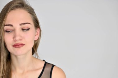 Beyaz arka planda kozmetik reklamcılığı için genel kadın portresi konsepti. Uzun saçlı ve mükemmel makyajlı güzel bir kızın büyük bir fotoğrafı farklı pozlarda duruyor..