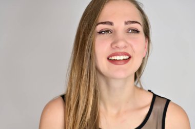 Beyaz arka planda kozmetik reklamcılığı için genel kadın portresi konsepti. Uzun saçlı ve mükemmel makyajlı güzel bir kızın büyük bir fotoğrafı farklı pozlarda duruyor..