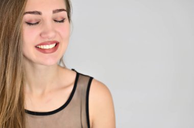 Beyaz arka planda kozmetik reklamcılığı için genel kadın portresi konsepti. Uzun saçlı ve mükemmel makyajlı güzel bir kızın büyük bir fotoğrafı farklı pozlarda duruyor..