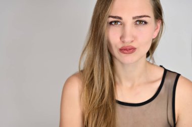 Beyaz arka planda kozmetik reklamcılığı için genel kadın portresi konsepti. Uzun saçlı ve mükemmel makyajlı güzel bir kızın büyük bir fotoğrafı farklı pozlarda duruyor..