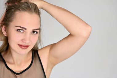 Beyaz arka planda kozmetik reklamcılığı için genel kadın portresi konsepti. Uzun saçlı ve mükemmel makyajlı güzel bir kızın büyük bir fotoğrafı farklı pozlarda duruyor..